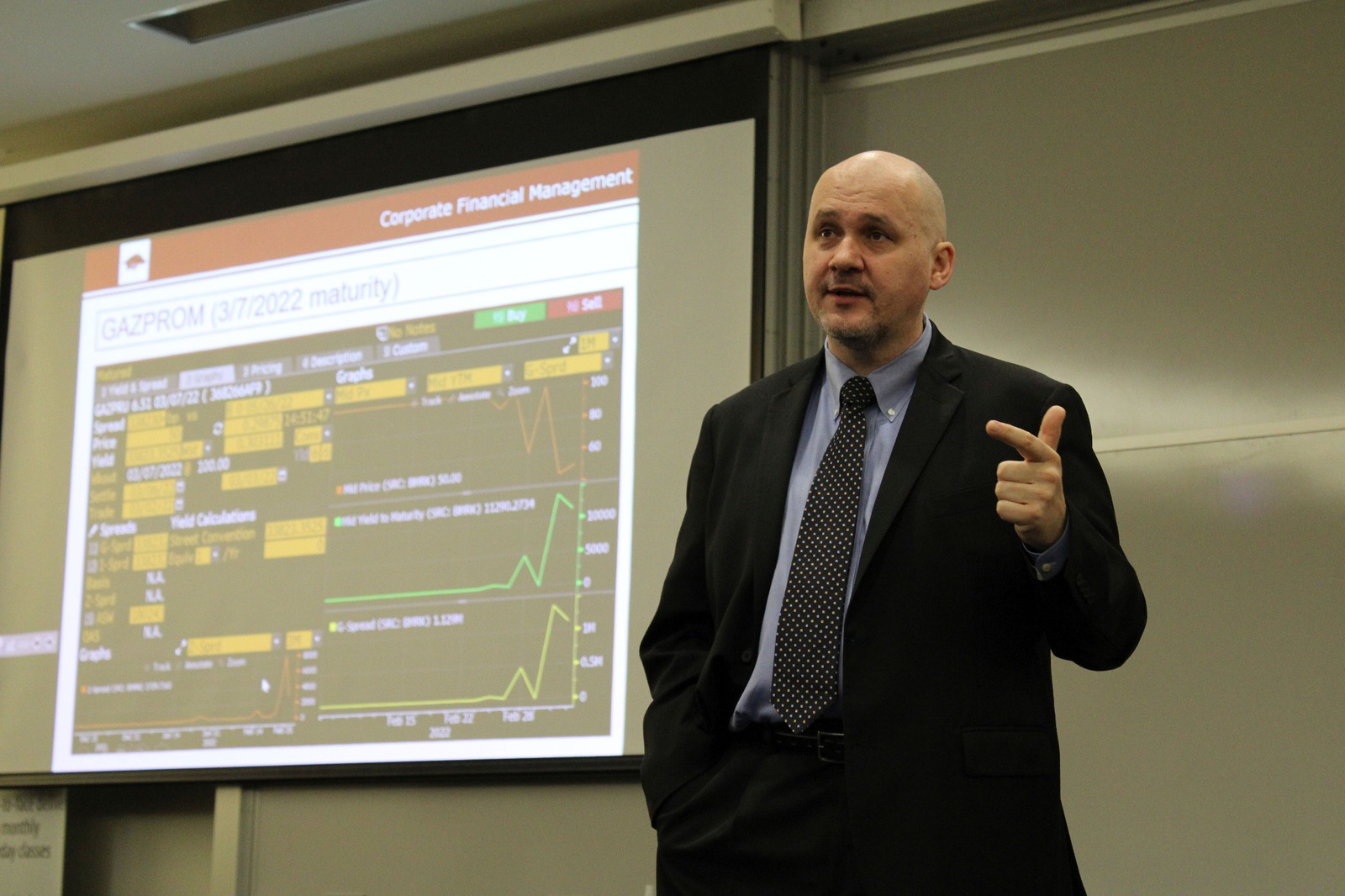 Tomas Jandik teaching corporate finance with bond analysis displayed behind him